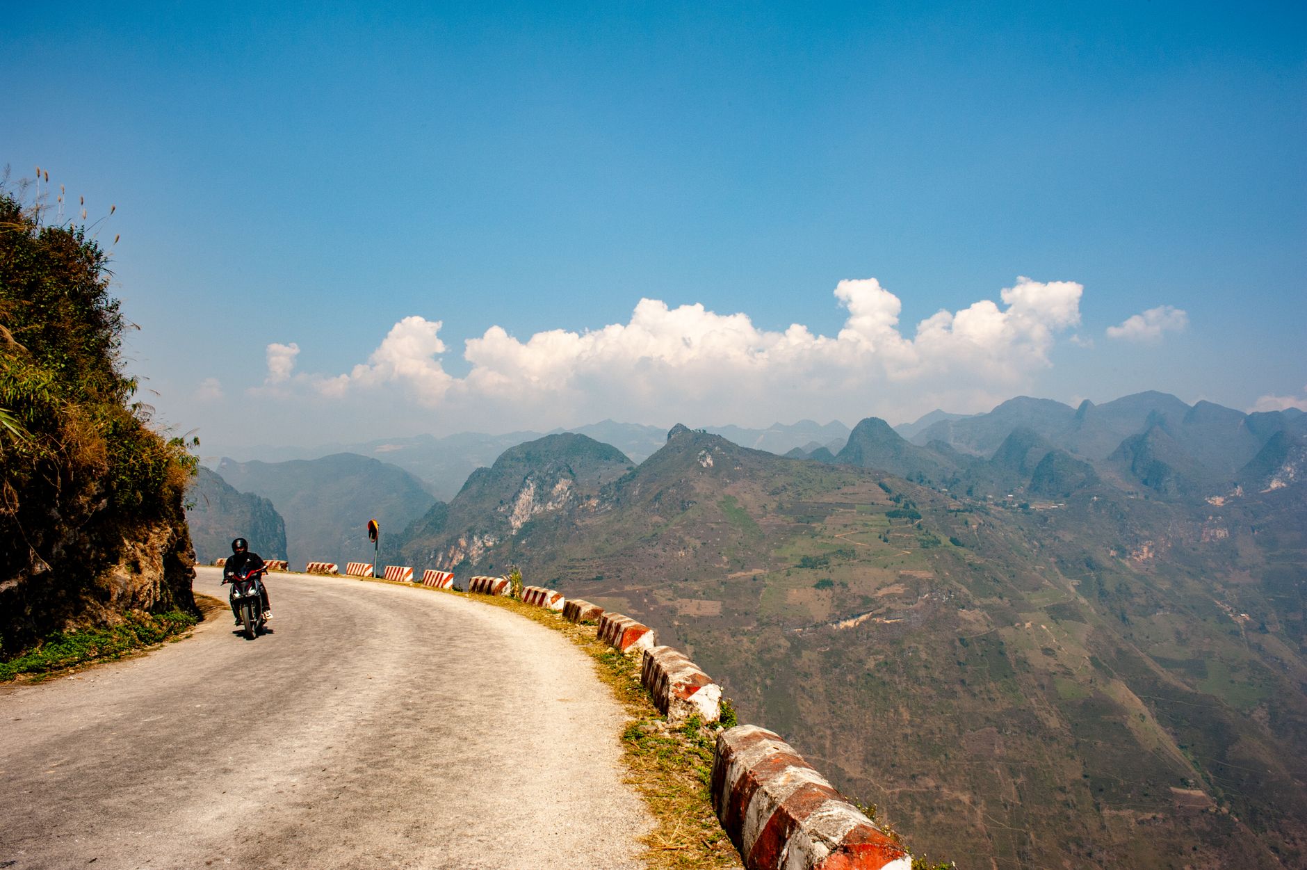Motorcyclist on the winding mountain road of Ma Pi Leng Pass, Ha Giang Loop, northern Vietnam