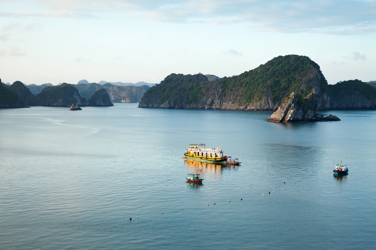 Boat on turquoise water near limestone mountains, Vietnam