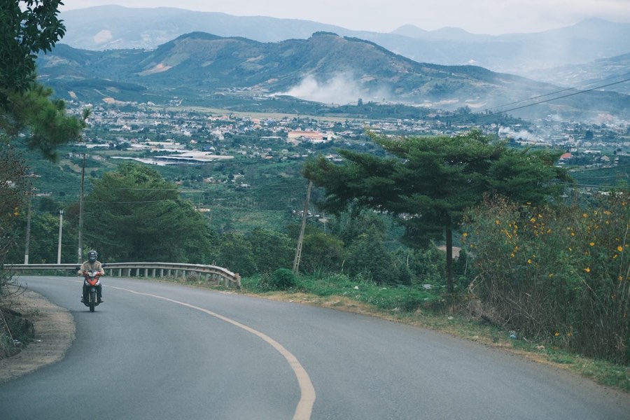 Motorcyclist riding a winding road through the Da Lat highlands, Vietnam