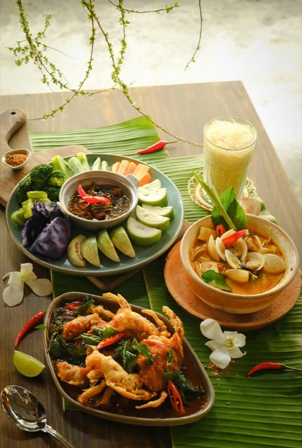 Spread of Vietnamese dishes including seafood, crab, and vegetables with dipping sauces on banana leaves, Ho Chi Minh City, Vietnam