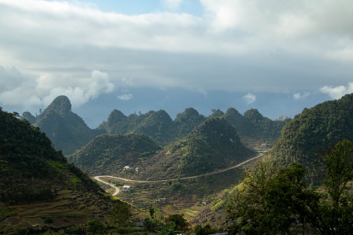 Winding mountain road through lush green hills, Ha Giang Loop, Vietnam