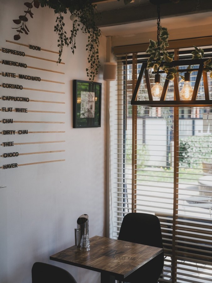 Sunlit cafe interior in Hoi An's ancient town with Vietnamese coffee and tropical foliage