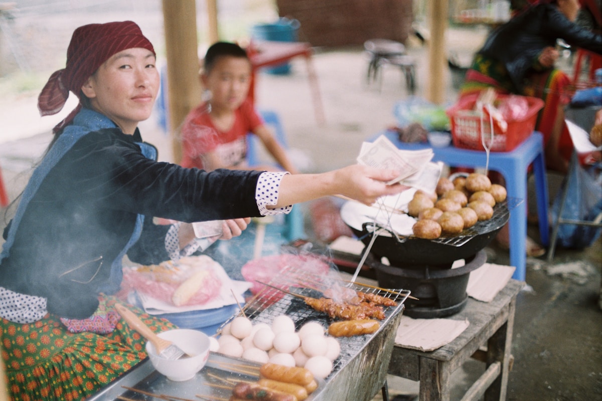 Vietnamese street food vendor preparing grilled food at a traditional market stall