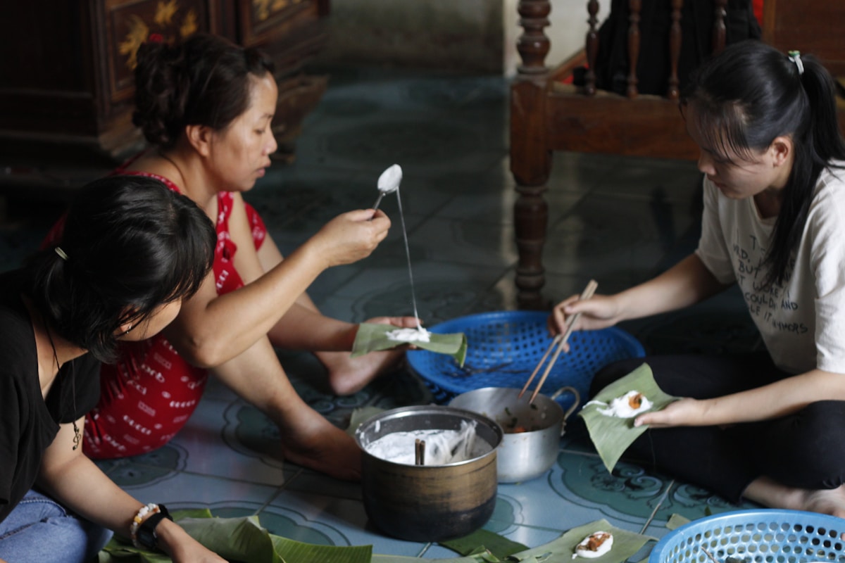 Women preparing food together on the floor, Hue, Vietnam