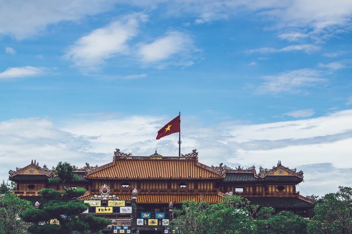 The Ngo Mon Gate of Hue Imperial City with Vietnam flag flying above ornate royal pavilions