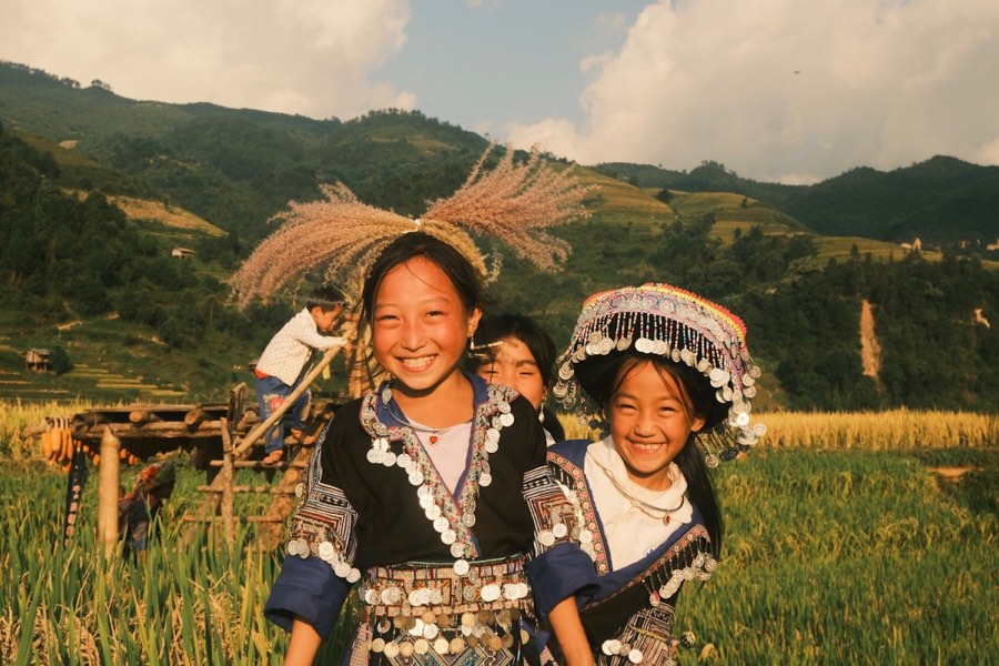 Group of people on a lush green hillside, Mu Cang Chai, Vietnam