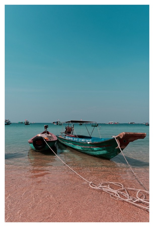 Traditional green fishing boat moored on a clear tropical beach, Phu Quoc, Vietnam
