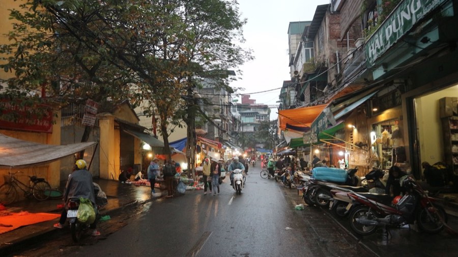 Bustling market street in Hanoi Old Quarter on a rainy evening, Vietnam