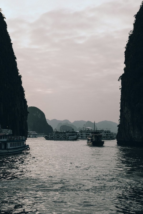 Cruise boats navigating through limestone karsts in Ha Long Bay, Vietnam