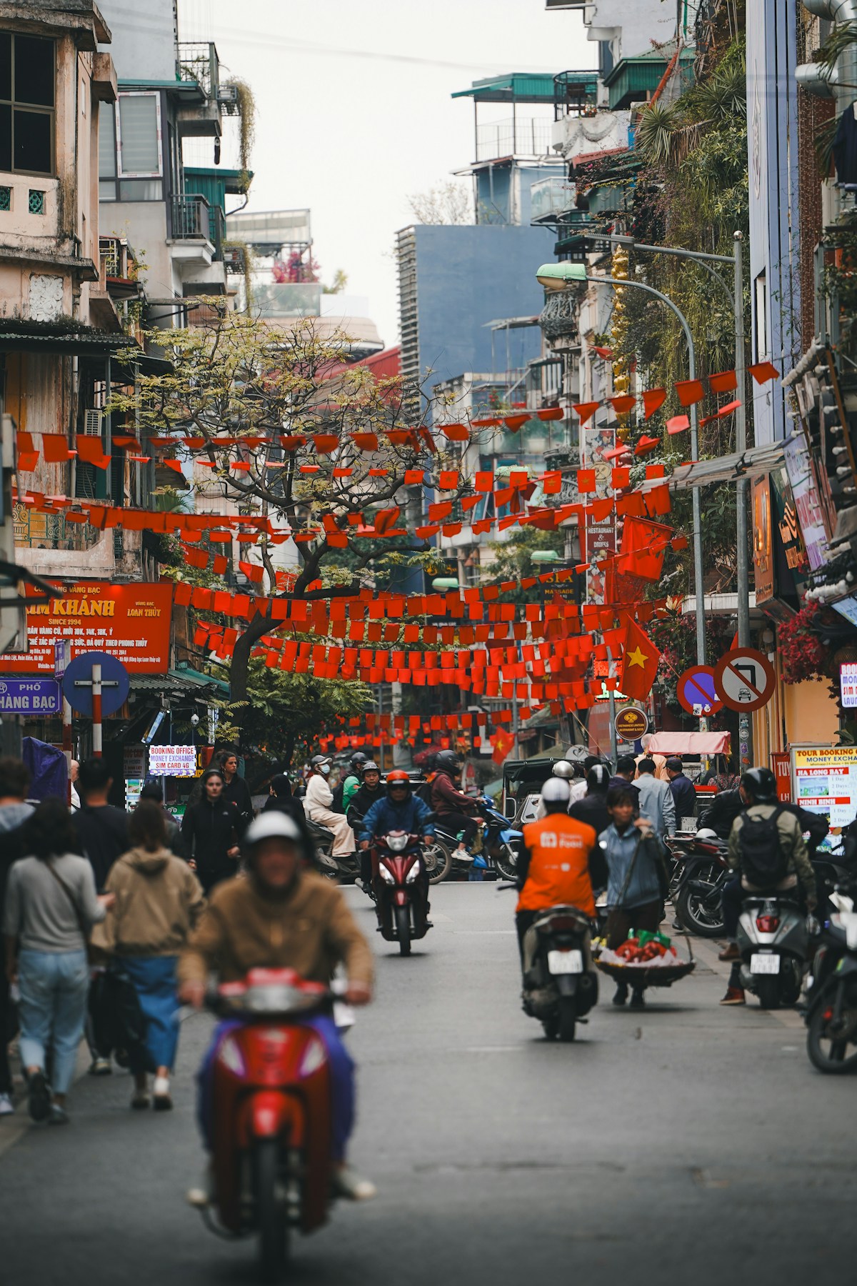 Busy street in Hanoi decorated with red banners and Vietnamese signs