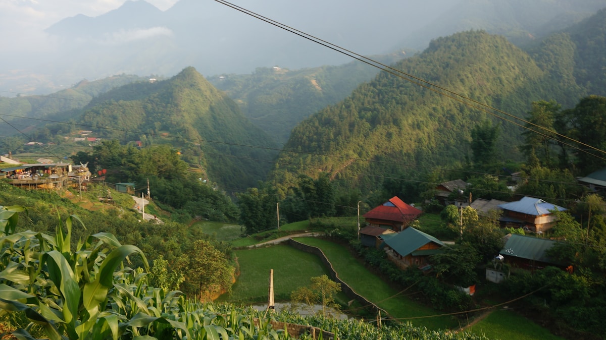 Green terraced hills with small village and mountains, Vietnam