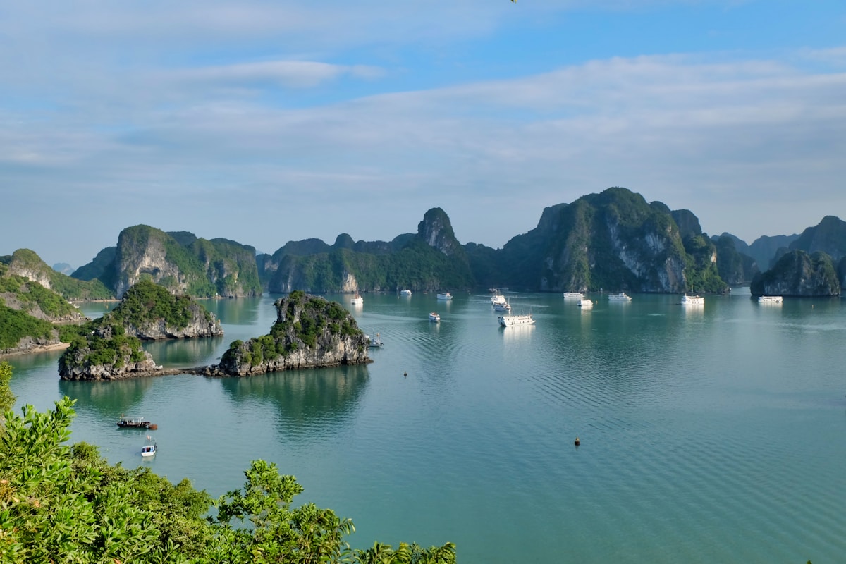 Split image showing Vietnam's Ha Long Bay limestone karsts and Thailand's turquoise Andaman Sea waters