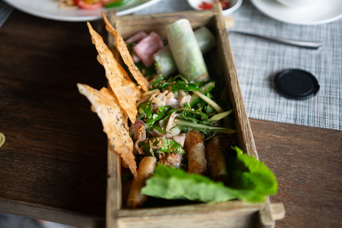 Vietnamese fresh spring rolls and crispy crackers served in a wooden tray
